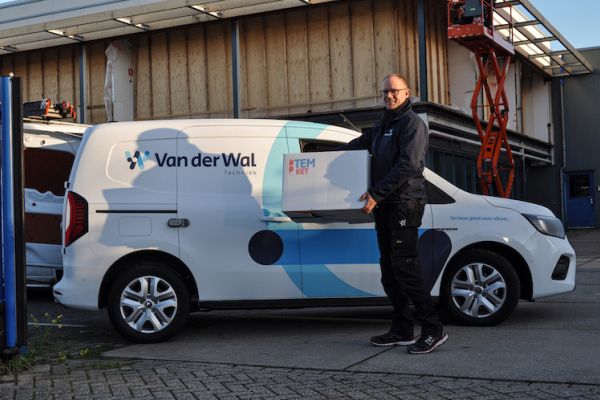 Medewerker Van der Wal Techniek met doos Temket isolatiematrassen bij bedrijfsbus.